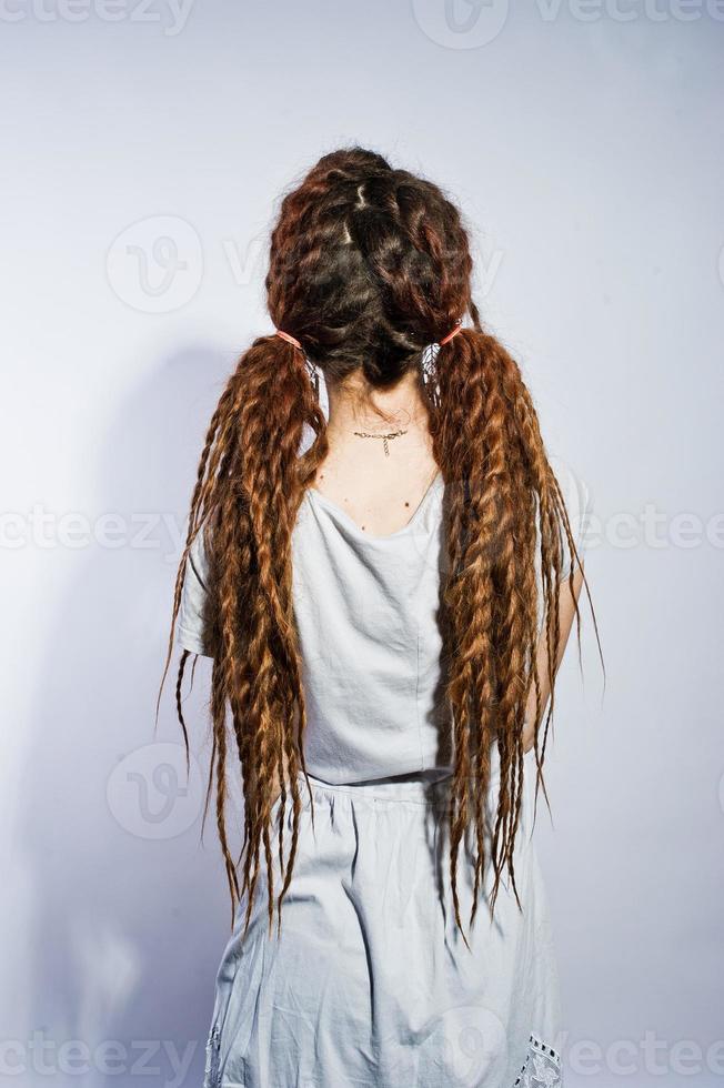 estúdio atirar nas costas da garota de vestido cinza com tranças dreads em fundo branco. foto