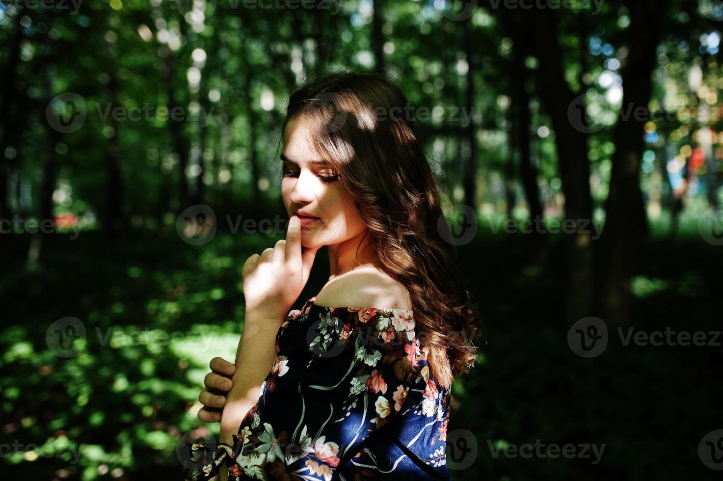 retrato de uma jovem fabulosa em um vestido bonito com elegante penteado encaracolado posando na floresta ou no parque. foto