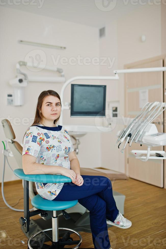 retrato de bebê dentista feminino em seu consultório odontológico. foto