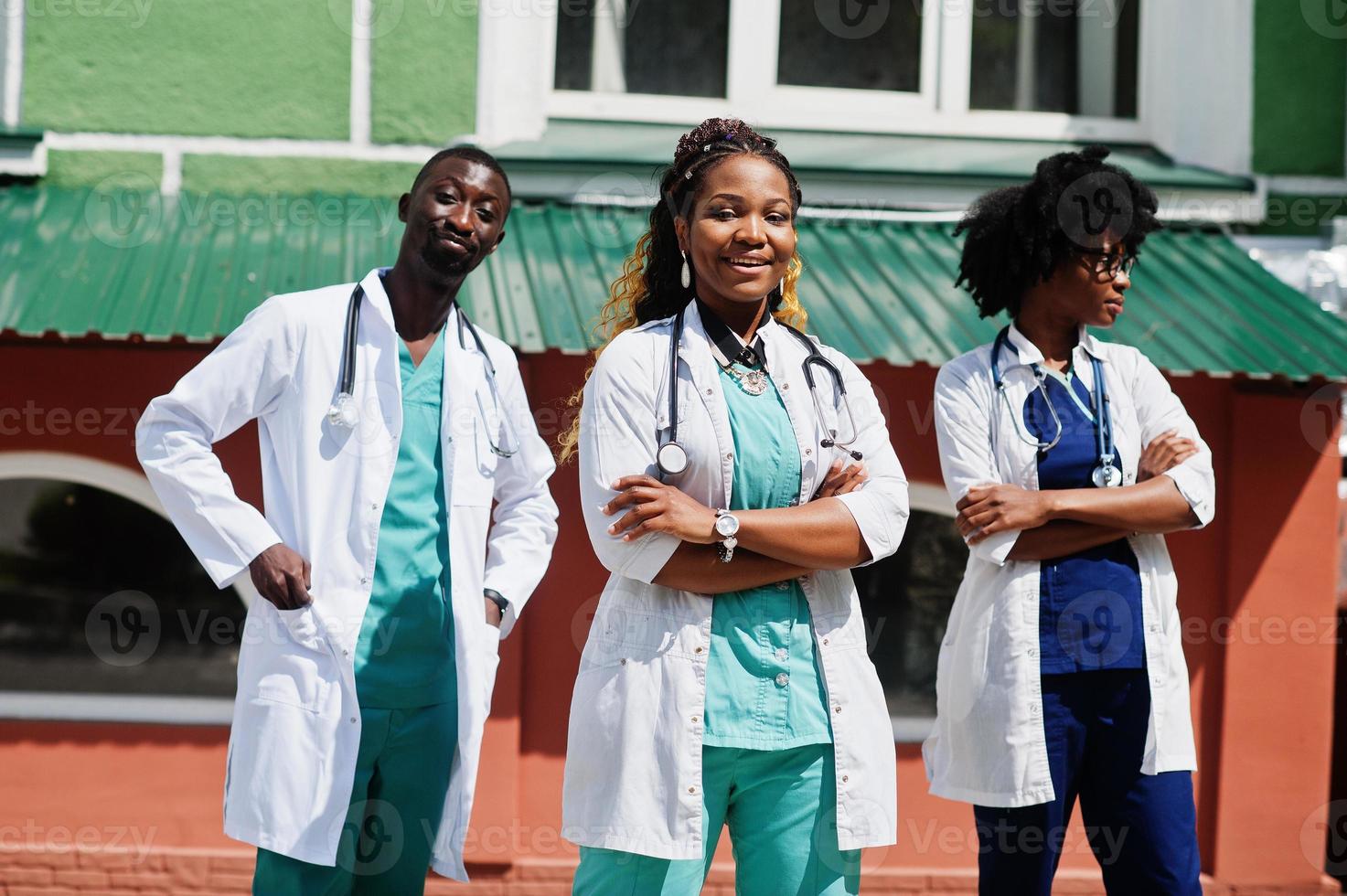 três médicos do grupo americano africano com estetoscópio vestindo jaleco. foto