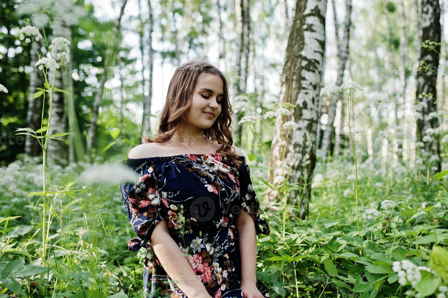 retrato de uma jovem fabulosa em um vestido bonito com elegante penteado encaracolado posando na floresta ou no parque. foto