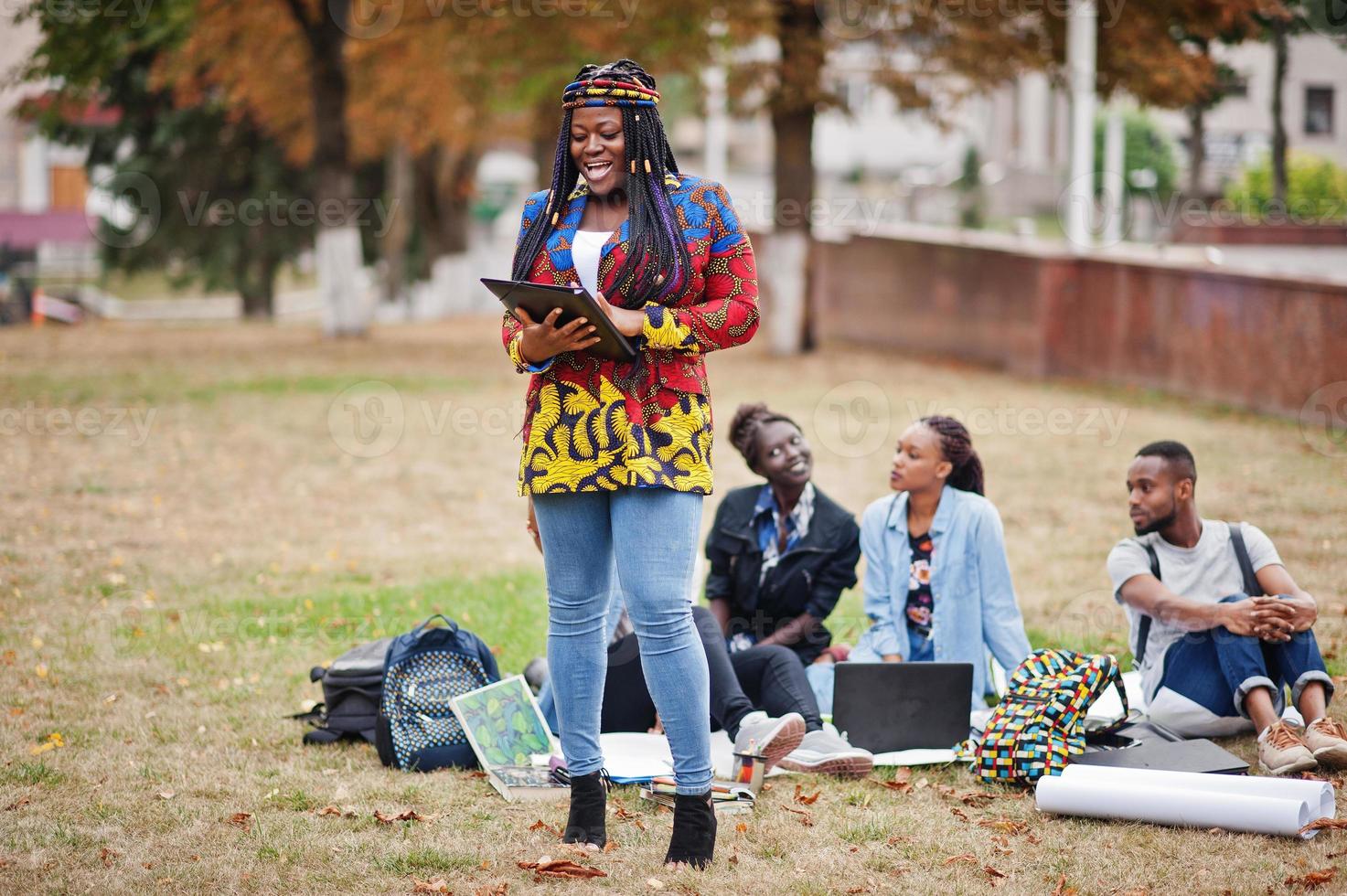 grupo de cinco estudantes universitários africanos passando tempo juntos no campus no pátio da universidade. amigos negros afro estudando. tema educação. foto