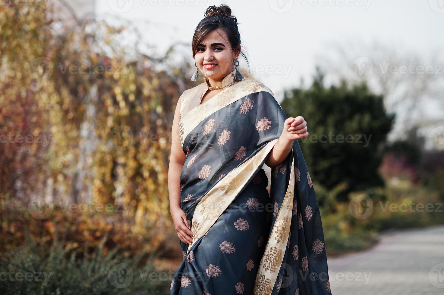 menina indiana do sul da Ásia morena elegante em saree andando ao ar livre. foto