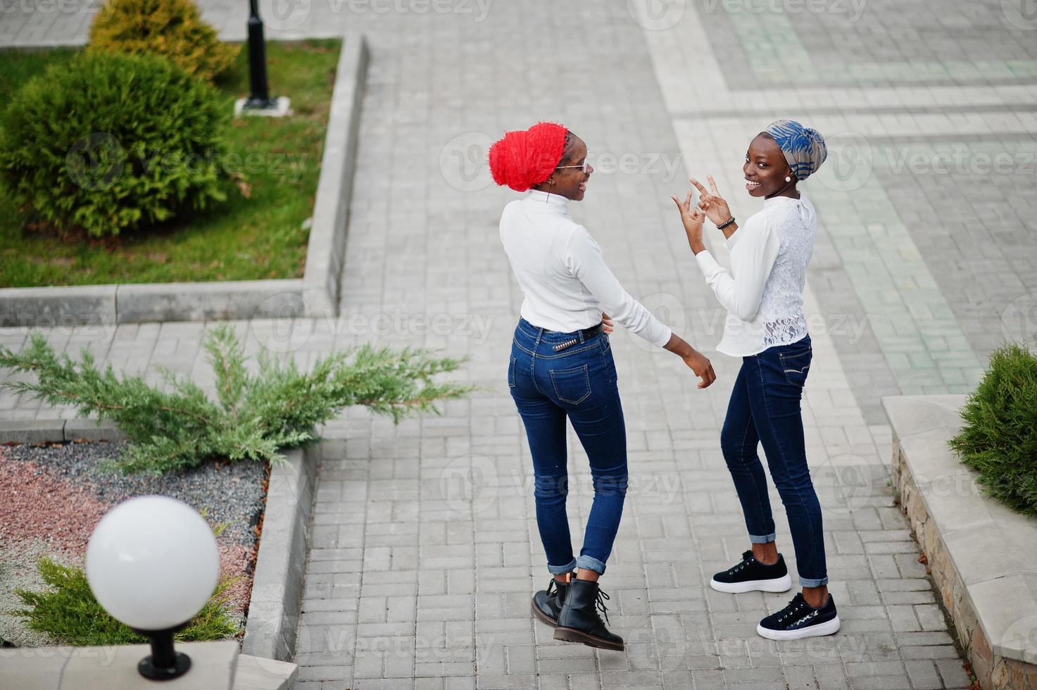 duas jovens muçulmanas africanas elegantes, atraentes, altas e magras no lenço de cabeça hijab ou turbante posaram juntos. foto