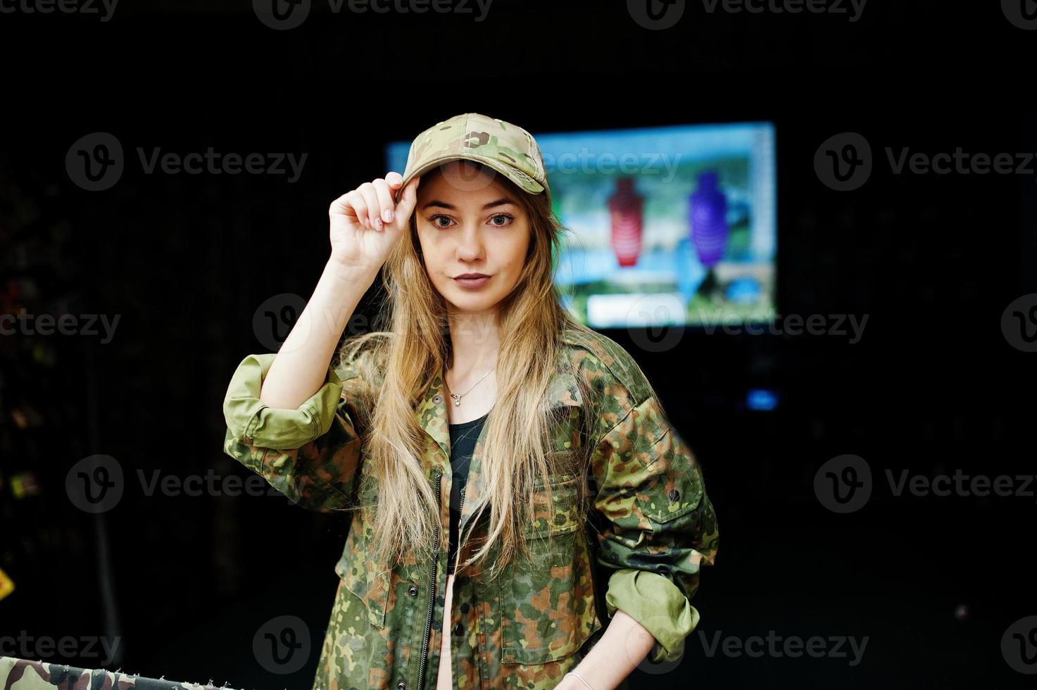 garota militar em uniforme de camuflagem contra o fundo do exército no campo de tiro. foto