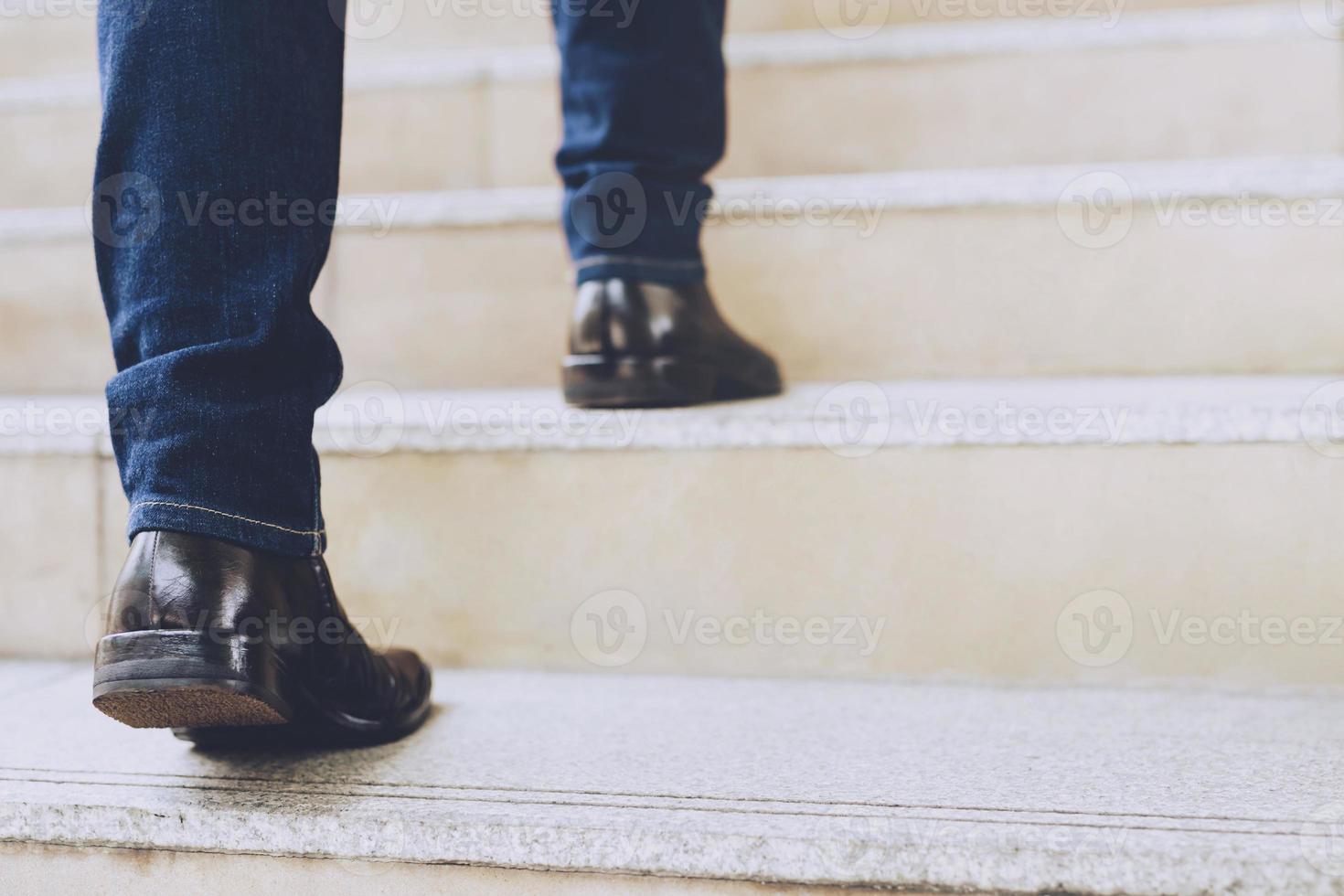 feche os sapatos das pernas do jovem empresário uma pessoa andando subindo as escadas na cidade moderna, suba, sucesso, cresça. com efeito quente vintage retrô de tons de filtro. escada foto