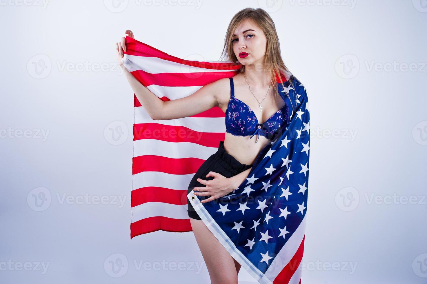 linda garota de sutiã e shorts com bandeira americana dos eua isolada no fundo branco. foto