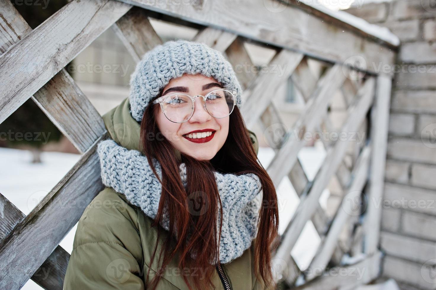 retrato de menina morena de cachecol cinza e chapéu, óculos no tempo frio. foto