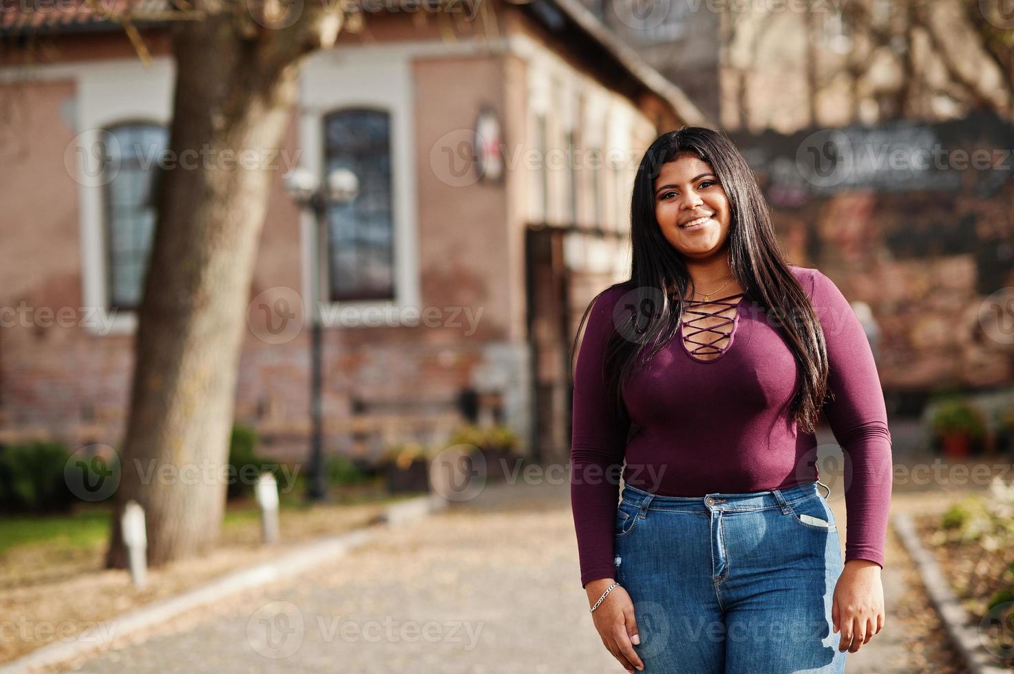 linda garota modelo latino xxl do equador veste blusa violeta posada na rua. foto