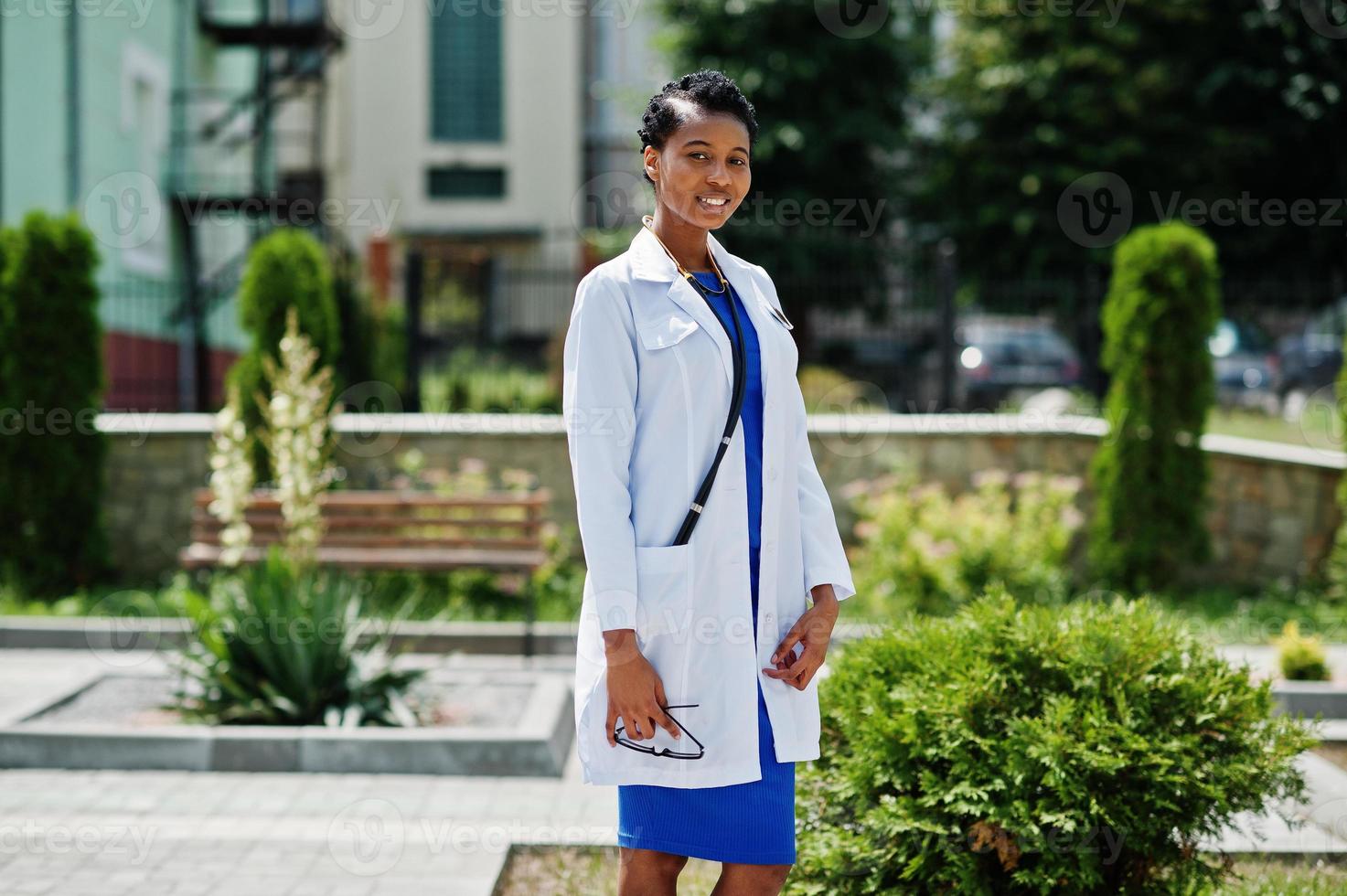 médico americano africano fêmea no jaleco com estetoscópio ao ar livre. foto