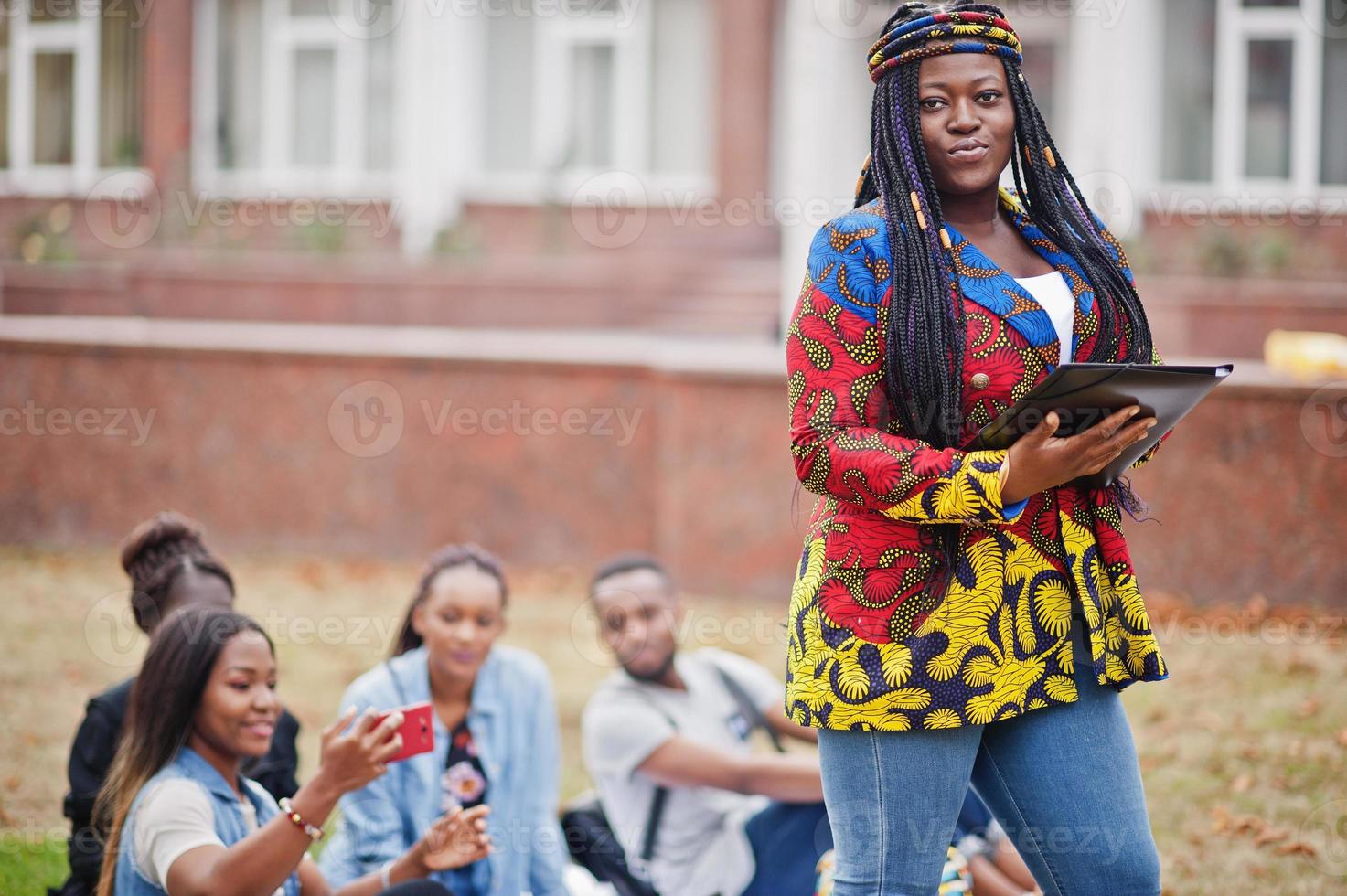 grupo de cinco estudantes universitários africanos passando tempo juntos no campus no pátio da universidade. amigos negros afro estudando. tema educação. foto