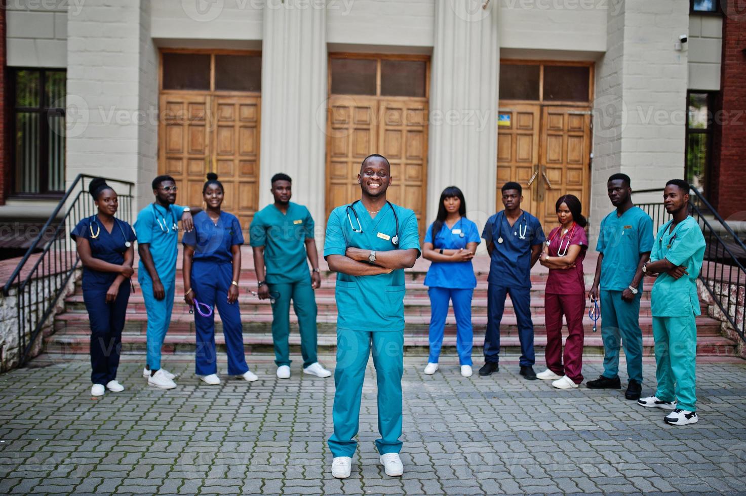 grupo de estudantes de medicina africanos posou ao ar livre contra a porta da universidade. foto