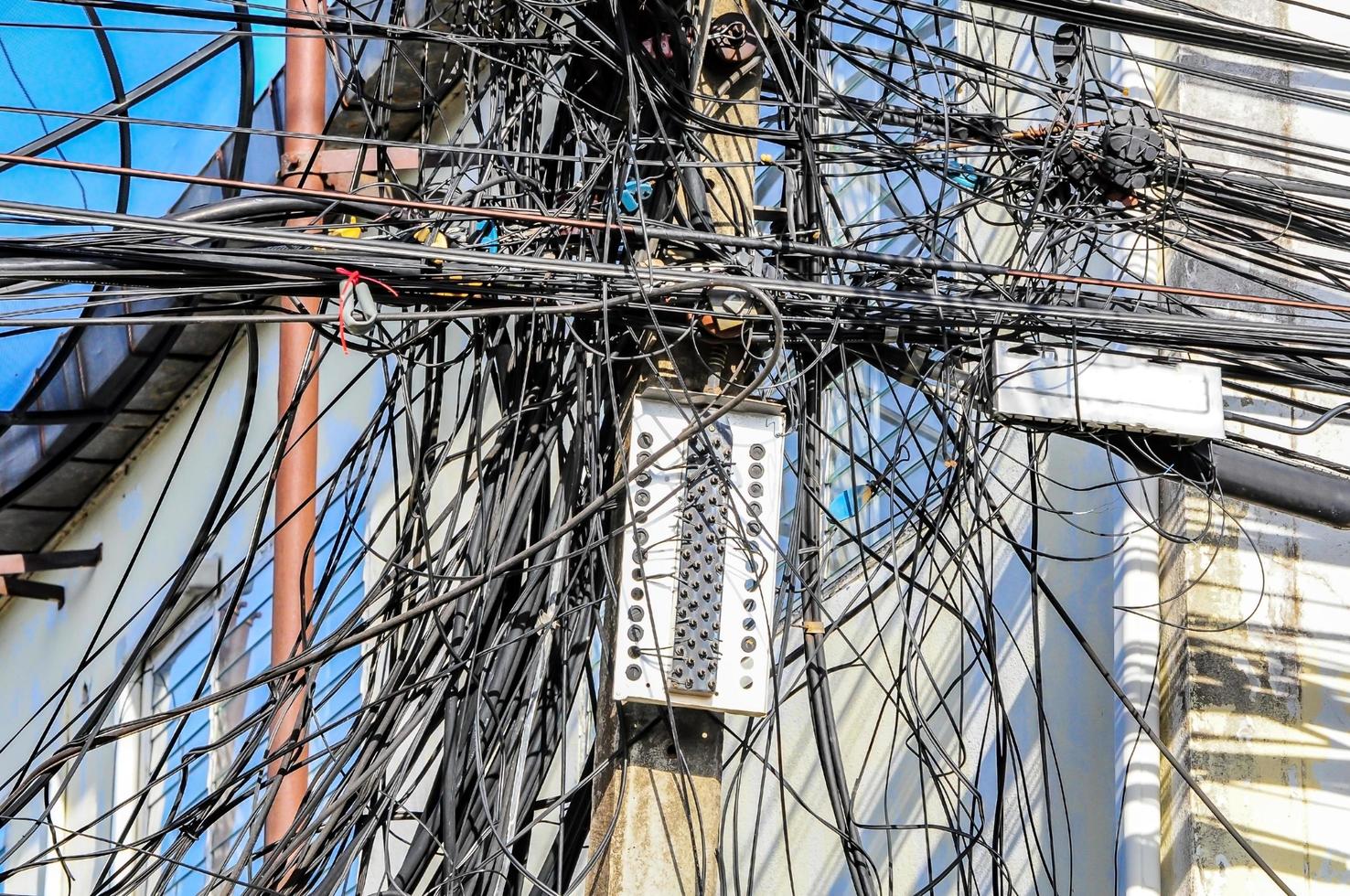 fios elétricos bagunçados no poste elétrico foto