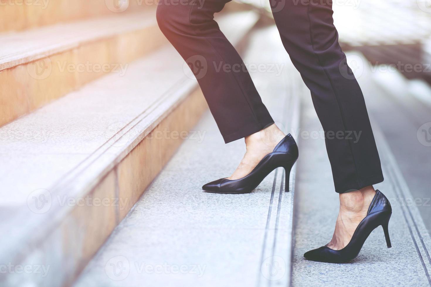 empresária moderna mulher trabalhadora close-up pernas subindo as escadas na cidade moderna na hora do rush para trabalhar no escritório com pressa. durante a primeira manhã de trabalho. deixe espaço para escrever texto descritivo foto