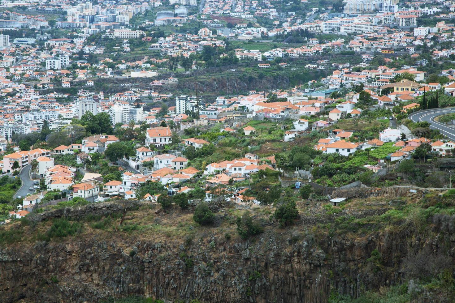 sol rompendo nuvens sobre tradicionais casas britânicas com campo ao fundo. iluminação dramática e cores quentes para dar um efeito caseiro. foto