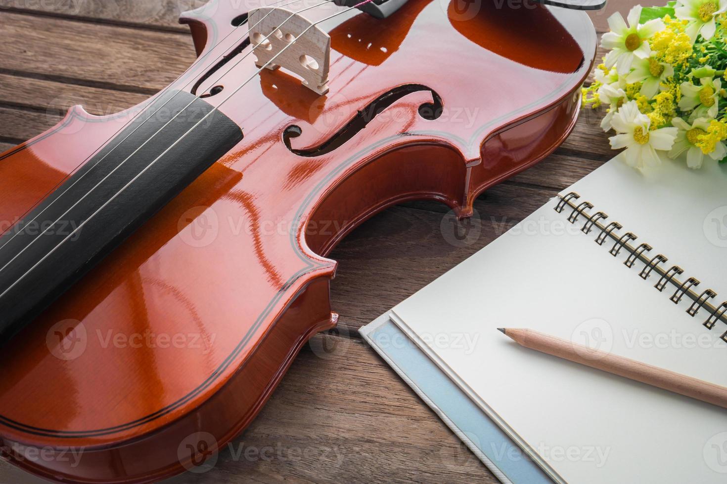 close-up de violino e livro na mesa de madeira foto