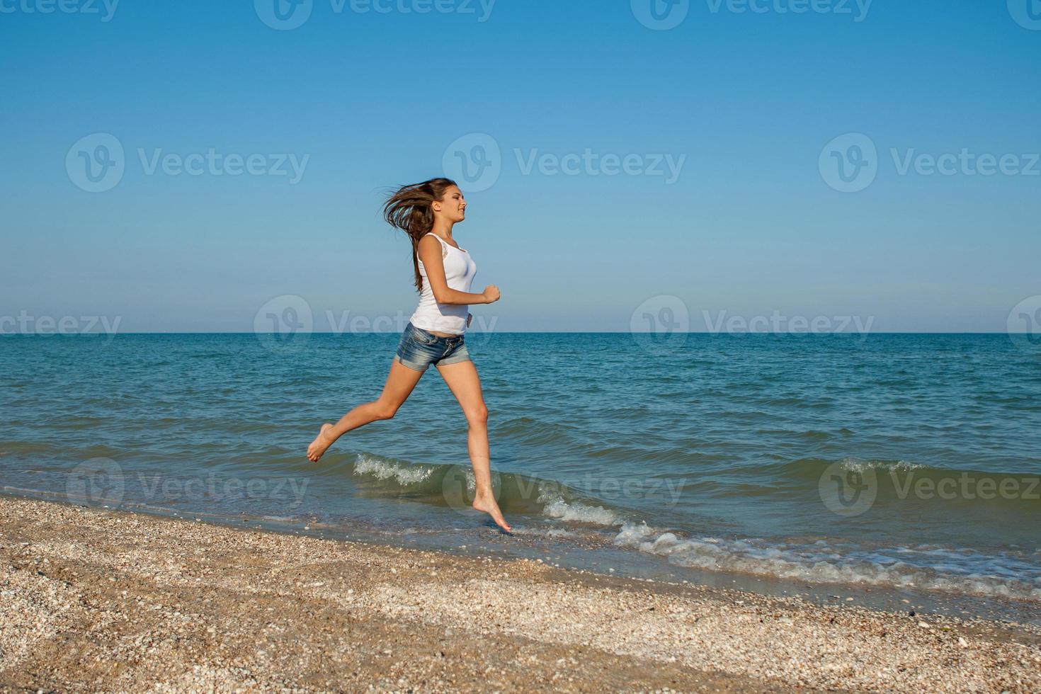 jovem corre no mar foto