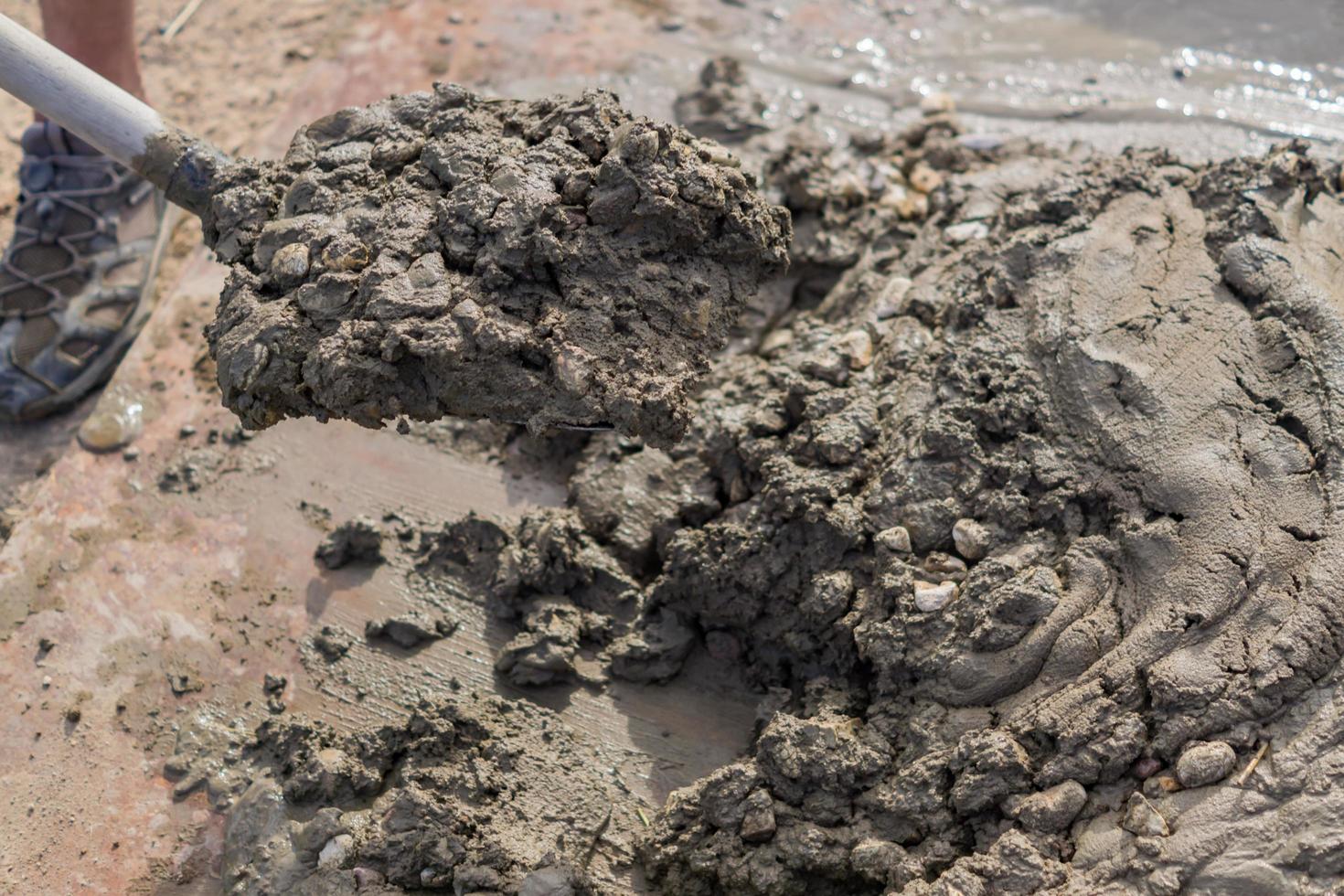 trabalhador misturando concreto e cascalho com pá na construção citar foto