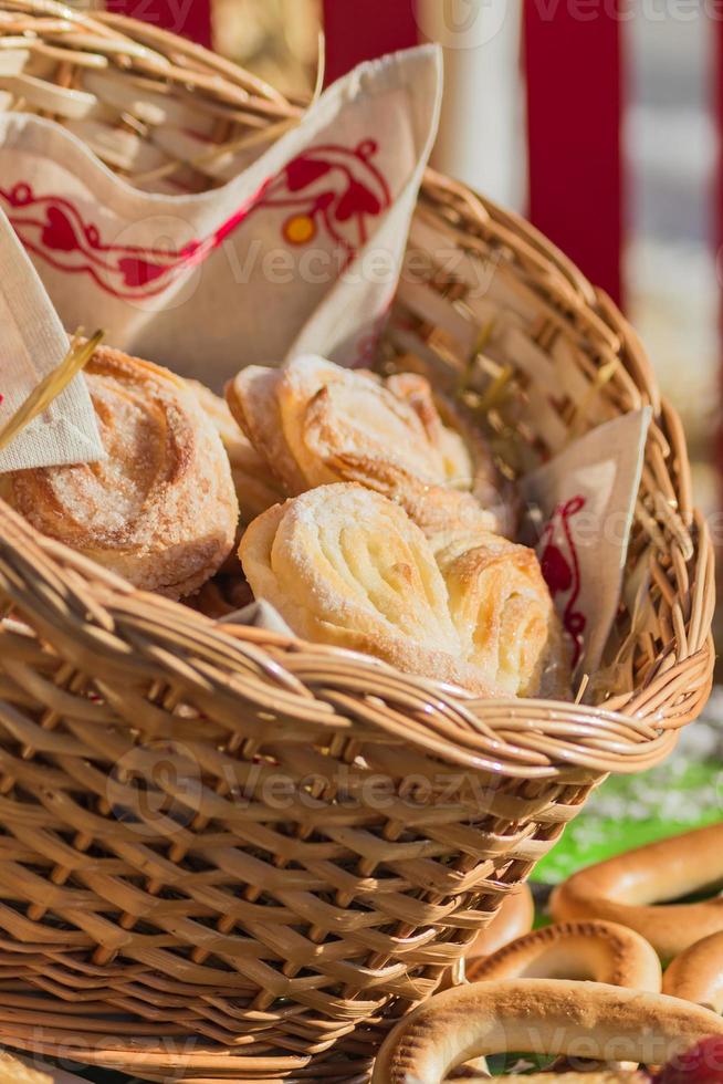 saborosos pães frescos na cesta de vime, iluminado pelo sol. foto