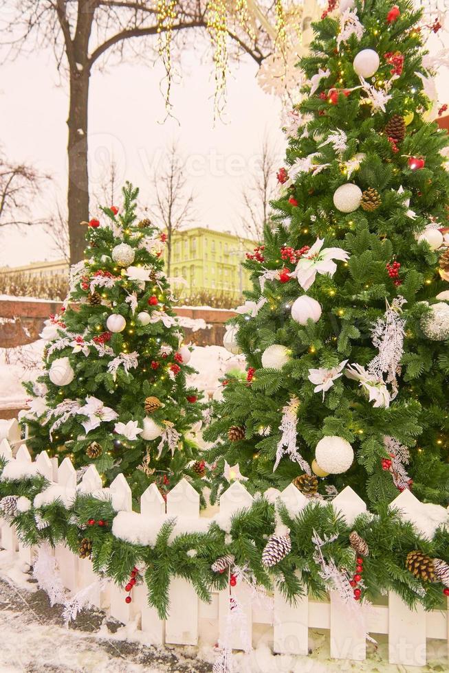 decoração de rua de natal. árvores de peles com bolas e guirlandas foto