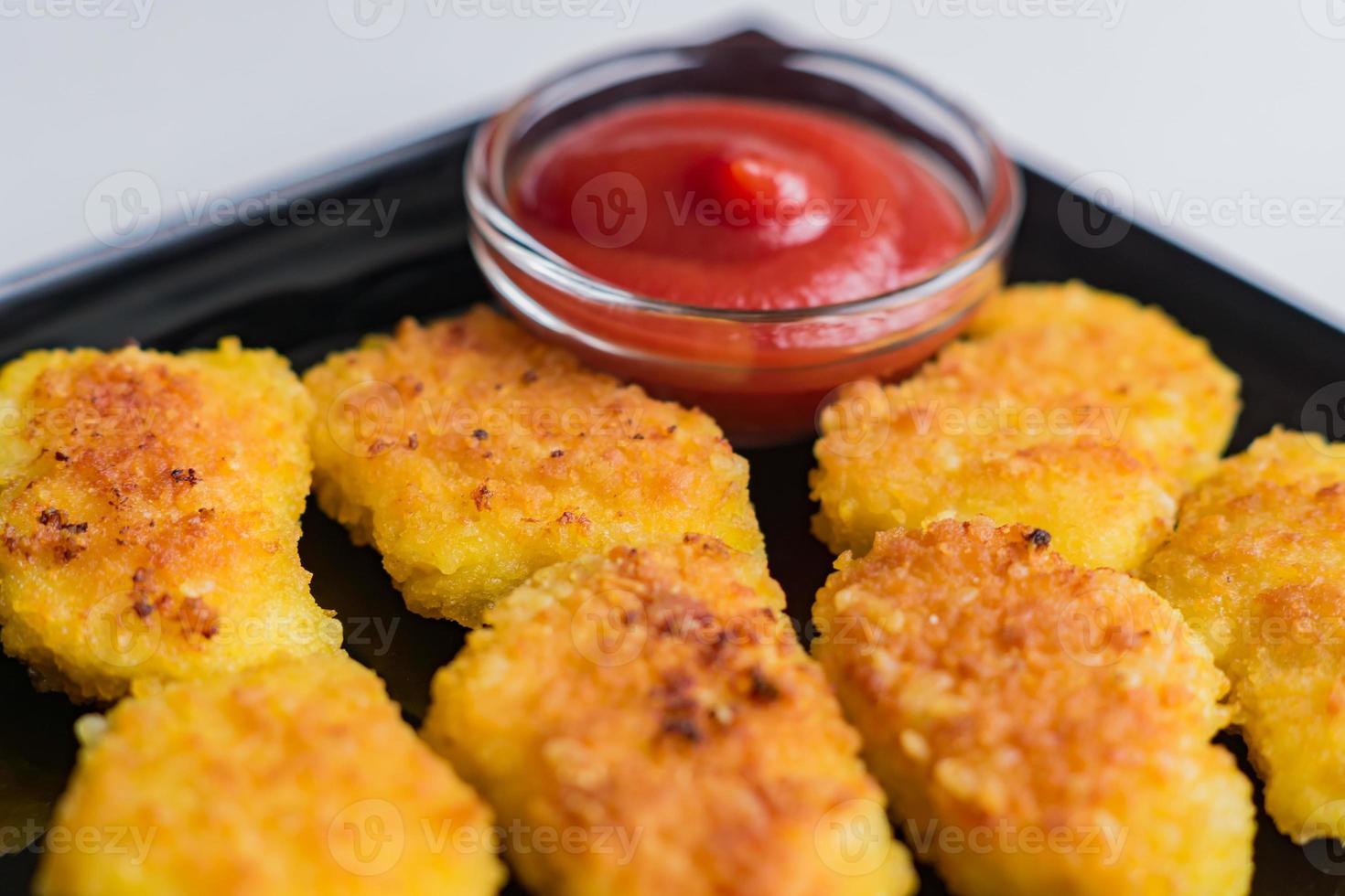 nuggets de frango crocante frito com ketchup na chapa preta. alimentos não saudáveis. foto