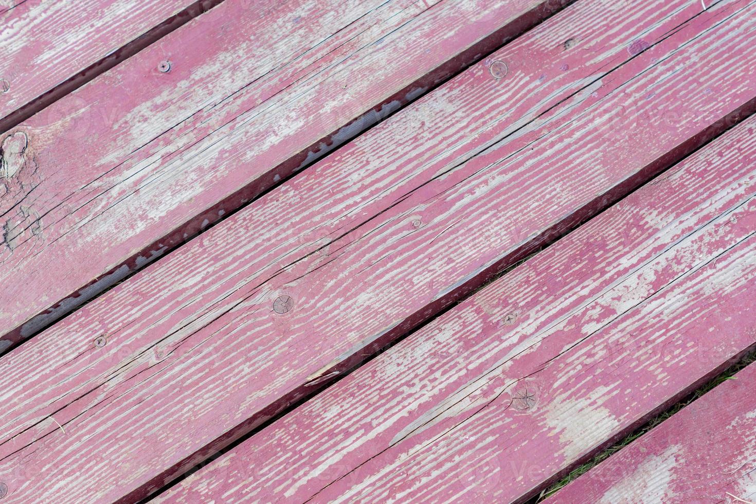 piso de madeira com tinta vermelha descascada. textura de fundo foto