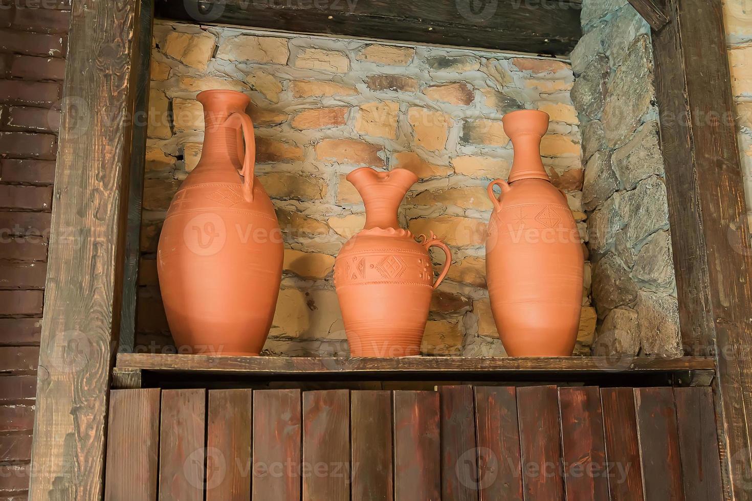 três vasos de barro na prateleira de madeira. decoração de interiores, estilo oriental foto