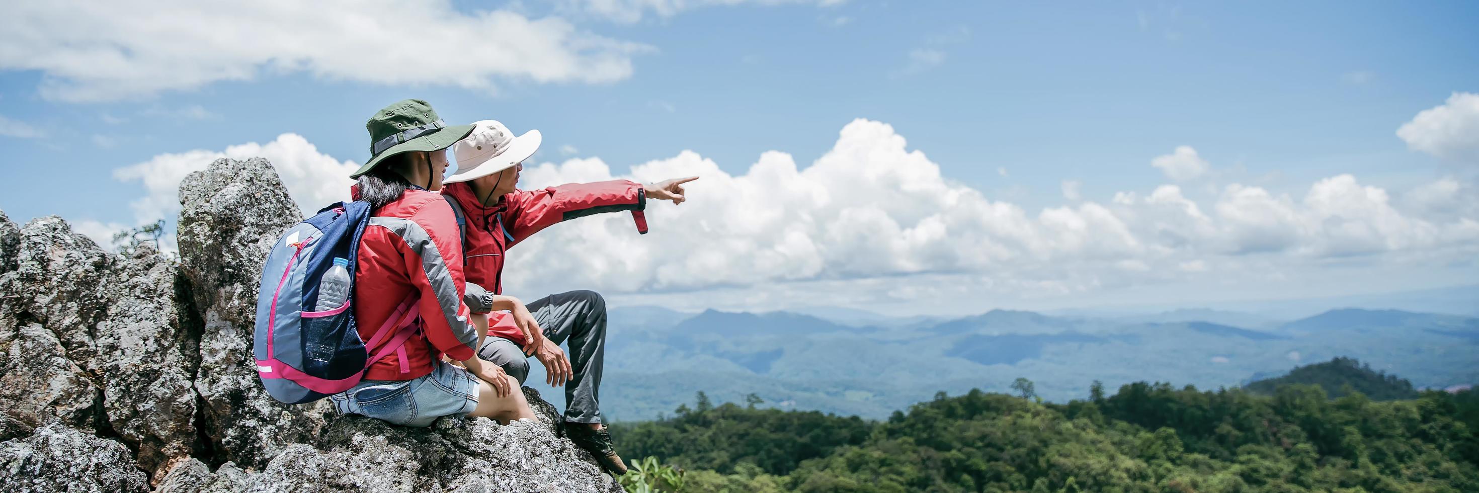 casal de jovem turista assistindo espetaculares paisagens montanhosas em altas montanhas. homem e mulher alpinista no topo da rocha. um casal de viajantes apaixonados. as pessoas saúdam o amanhecer. amantes viajam. espaço de cópia foto