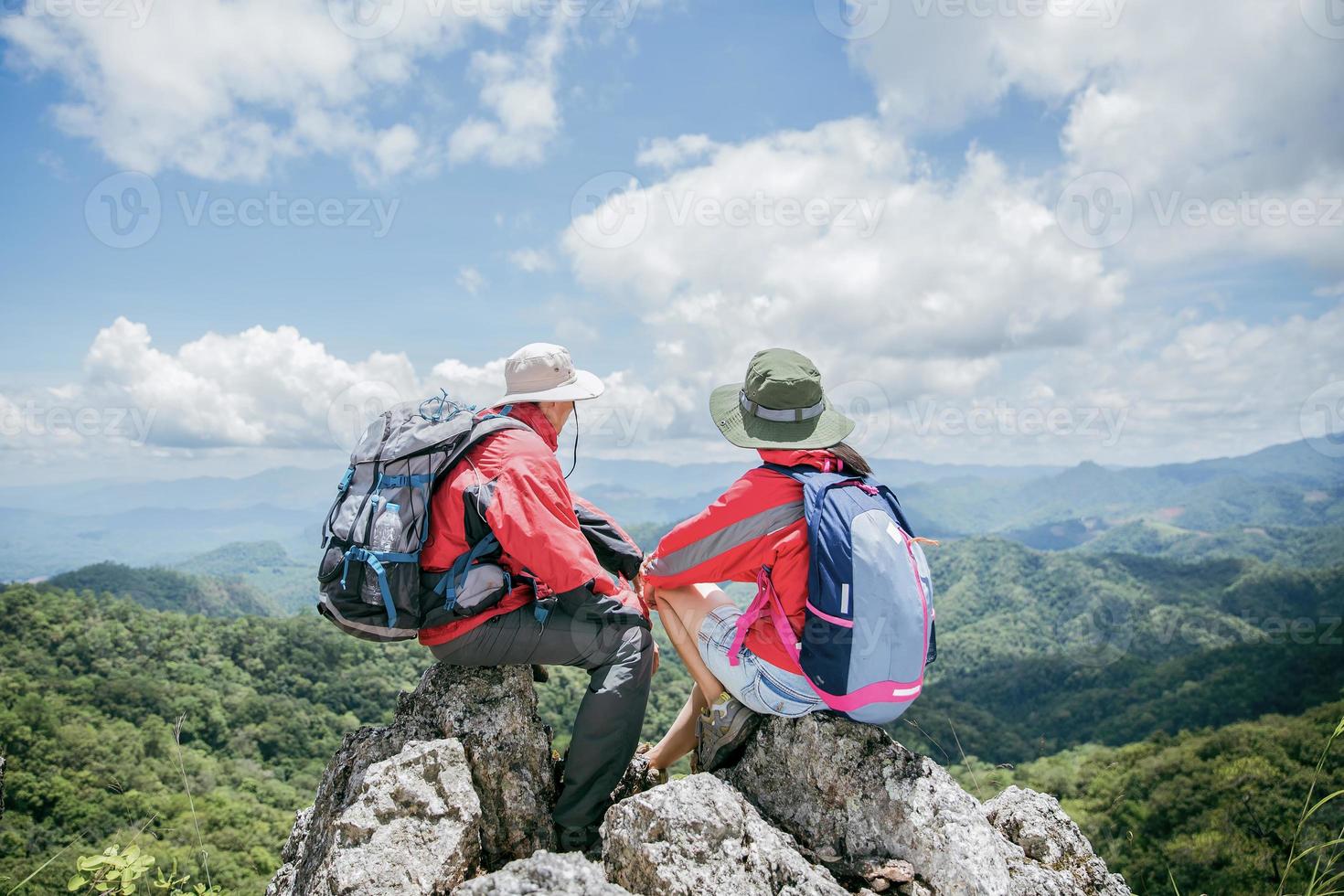 casal de jovem turista assistindo espetaculares paisagens montanhosas em altas montanhas. homem e mulher alpinista no topo da rocha. um casal de viajantes apaixonados. as pessoas saúdam o amanhecer. amantes viajam. espaço de cópia foto