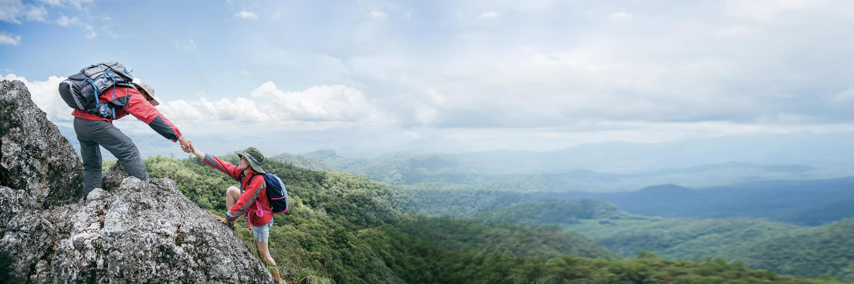 pessoa caminhada amigos ajudando uns aos outros na montanha. homem e mulher dando ajuda e estilo de vida ativo. casal caminhadas se ajudam. conceito de amizade, trabalho em equipe. banner com espaço de cópia foto