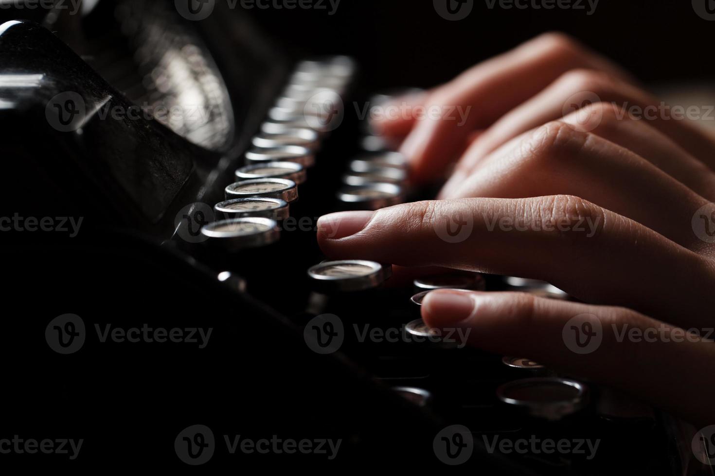 mãos escrevendo na velha máquina de escrever sobre fundo de madeira foto