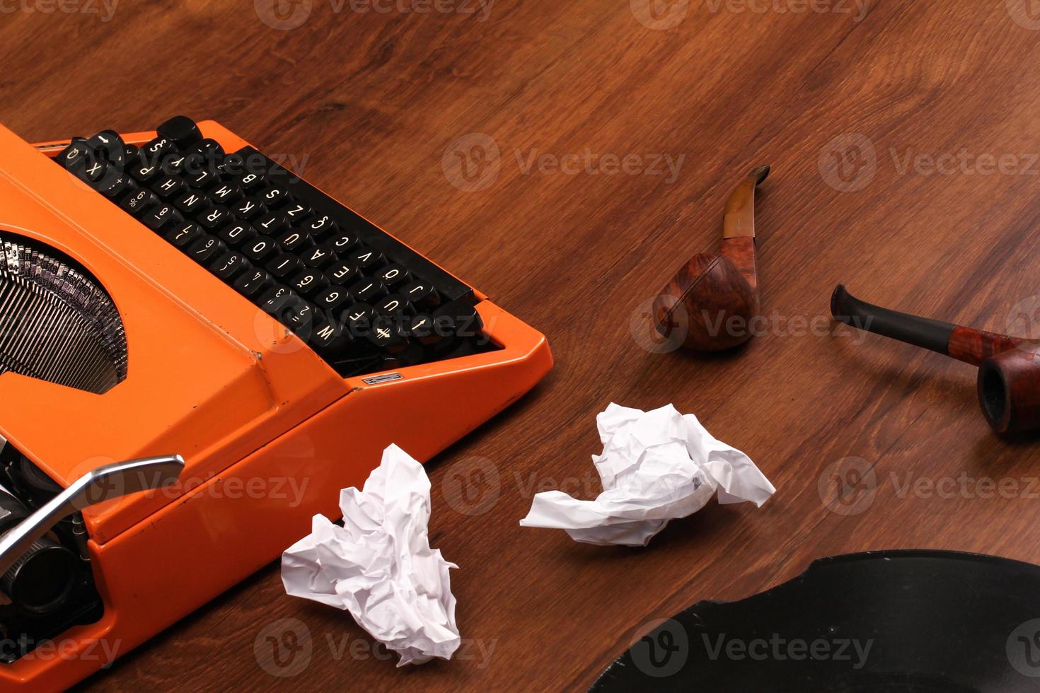 a máquina de escrever vintage laranja na madeira foto