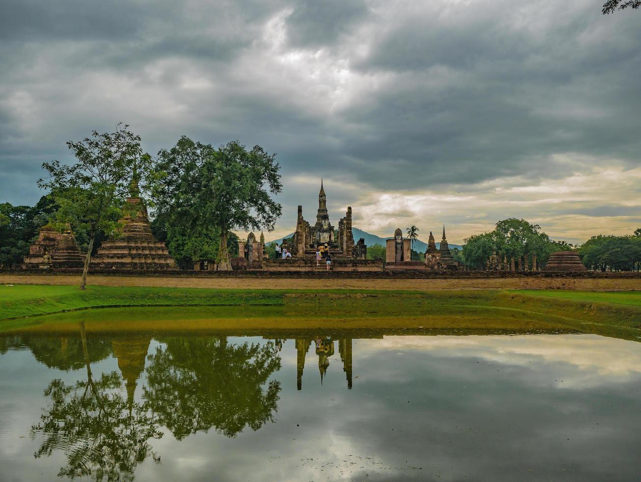 ruína do reflexo do pagode na água no parque histórico de sukhothai, cidade de sukhothai tailândia foto