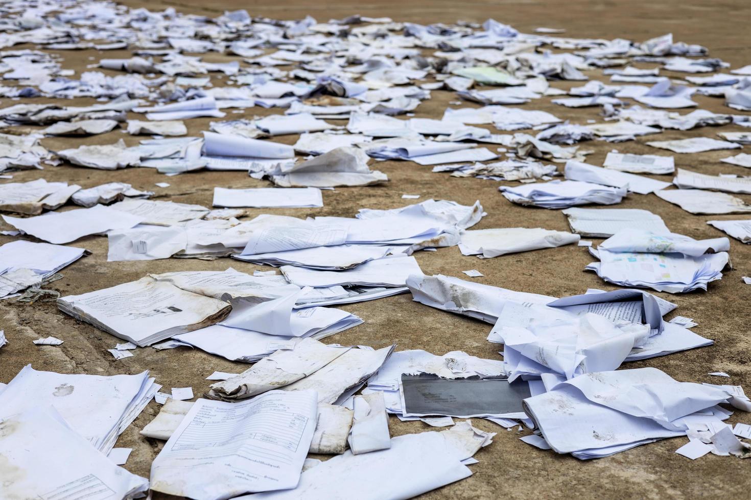 pedaços de papel quadrado velho de muitos cadernos estão espalhados no chão de concreto para secar. foto