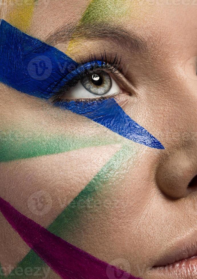 close-up do rosto de mulher com maquiagem multicolor foto