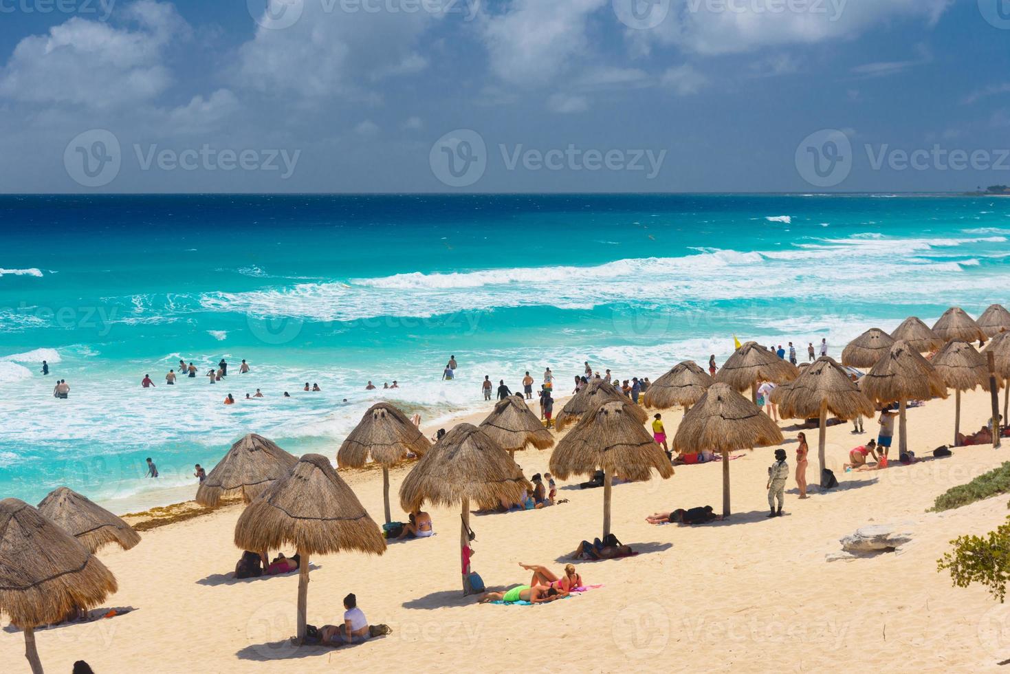 guarda-chuvas em uma praia de areia com água azul em um dia ensolarado perto de cancun, méxico foto