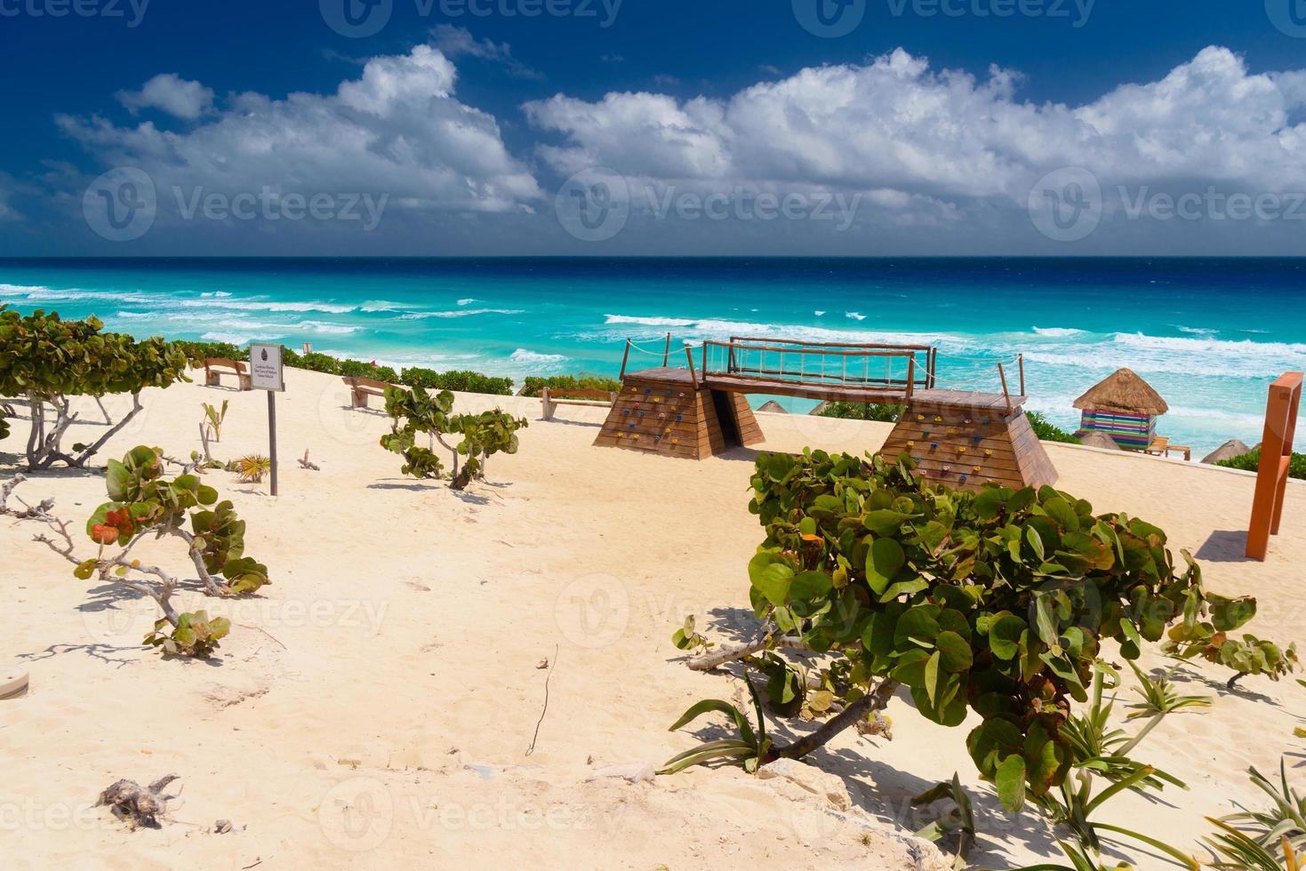 praia de areia com água azul em um dia ensolarado perto de cancun, méxico foto