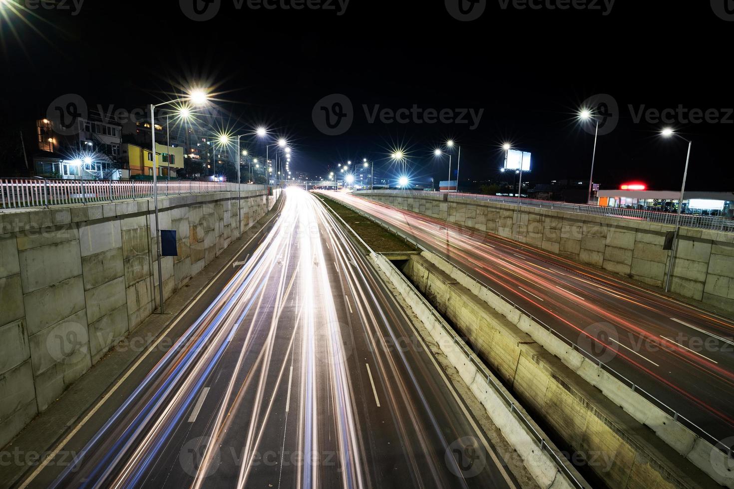 estrada de junção de tráfego noturno com luzes do movimento do veículo. visão horizontal foto
