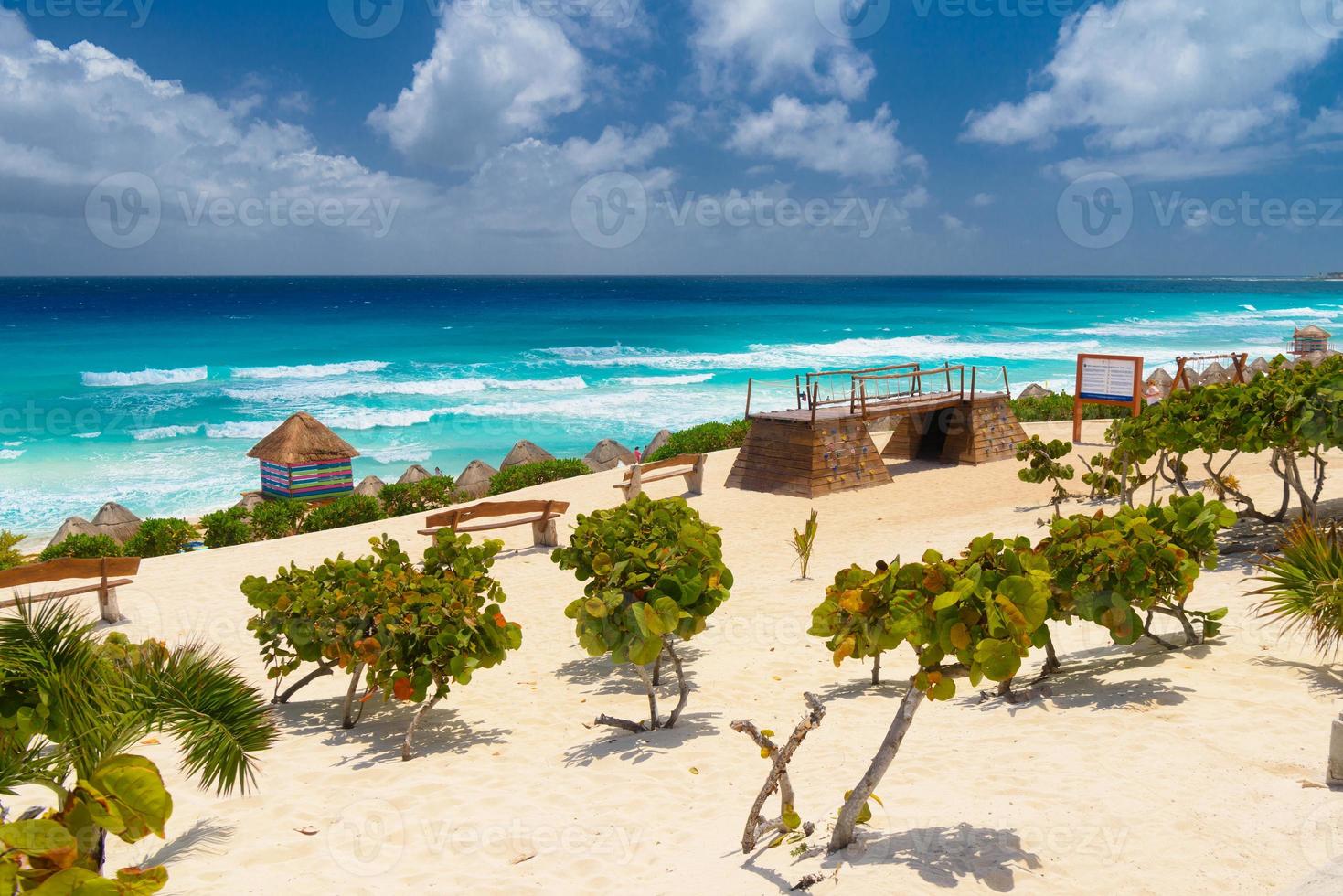 praia de areia com água azul em um dia ensolarado perto de cancun, méxico foto