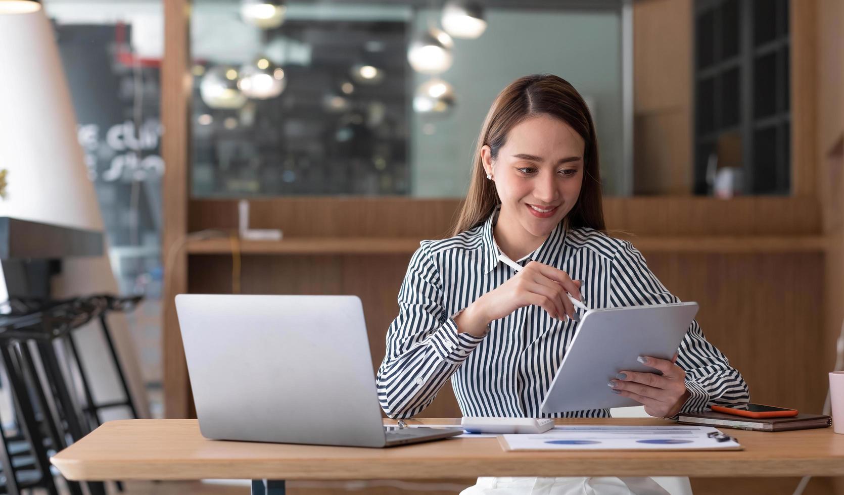 empresária usando um touchpad para ver seus e-mails em sua mesa no escritório. foto