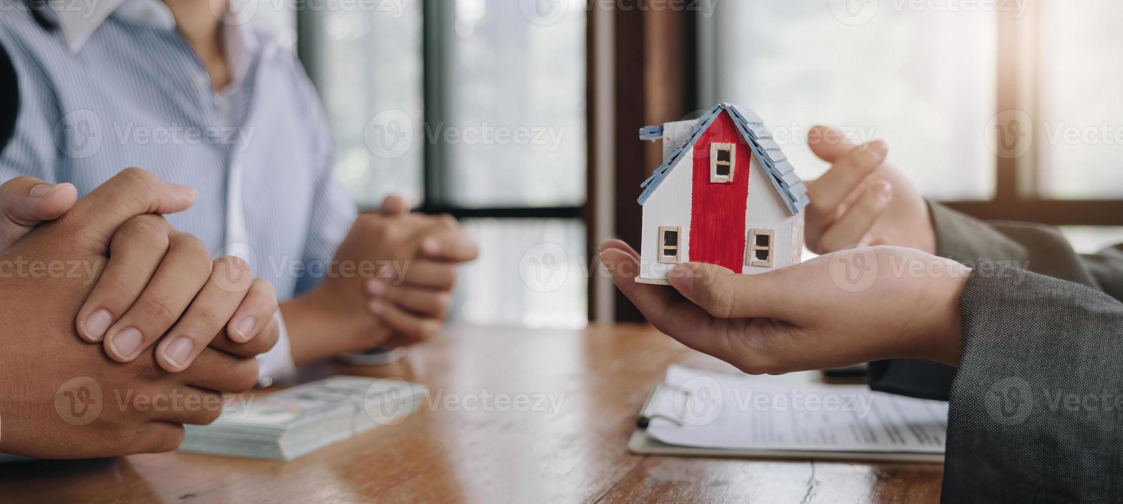 o agente imobiliário redige um contrato de moradia após o cliente ter pago a caução. discussão, negociação, feche o negócio foto