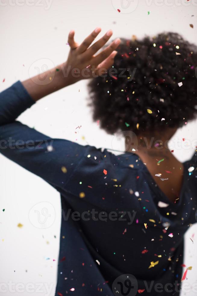 mulher afro-americana soprando confete no ar foto