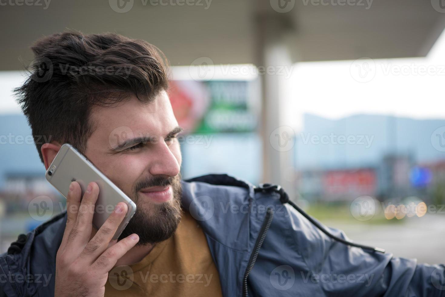 homem de negócios casual jovem bonito com barba usando telefone celular foto