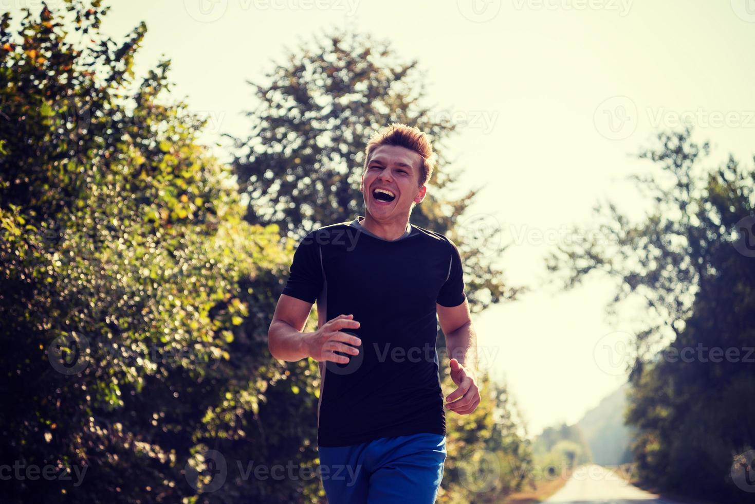 homem correndo ao longo de uma estrada rural foto