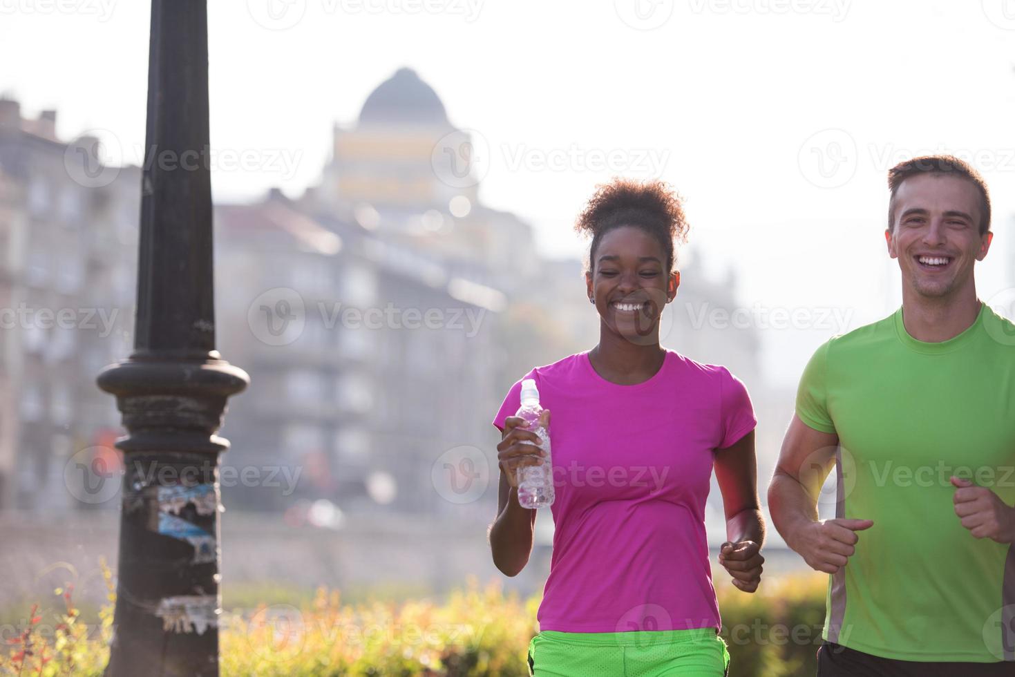 jovem casal multiétnico correndo na cidade foto