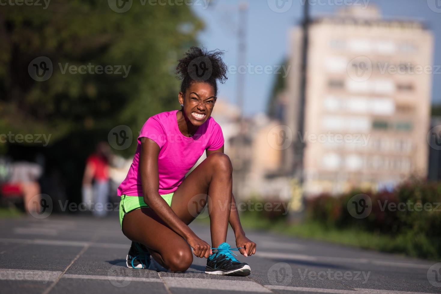 mulher afro-americana corredor apertando cadarço de sapato foto