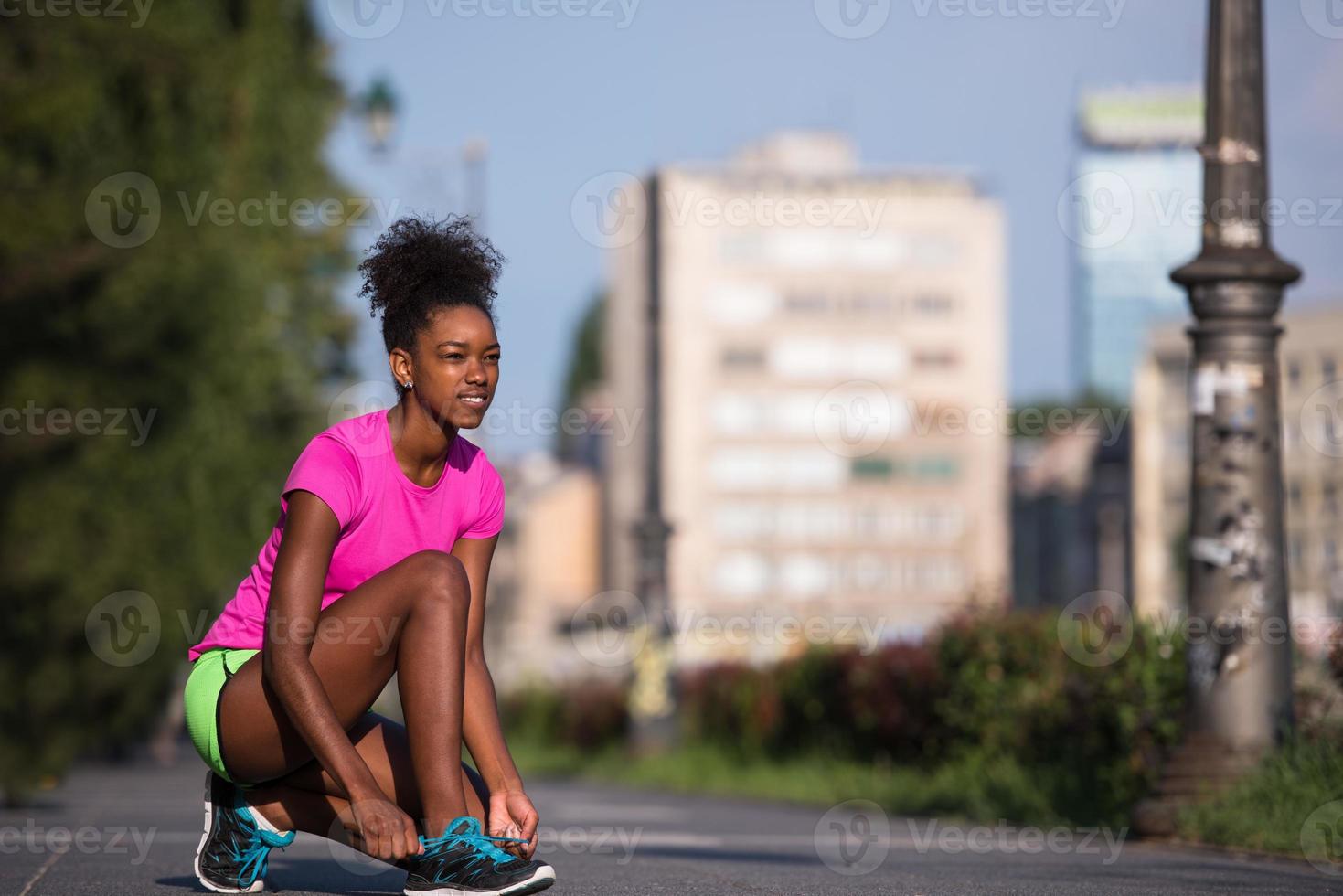 mulher afro-americana corredor apertando cadarço de sapato foto