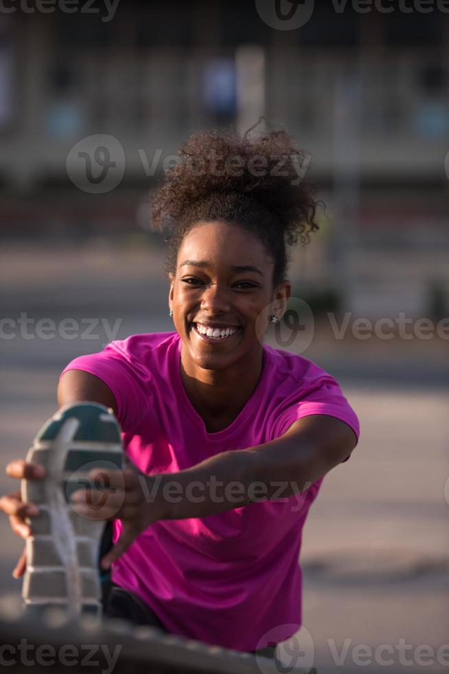 mulher afro-americana fazendo aquecimento e alongamento foto