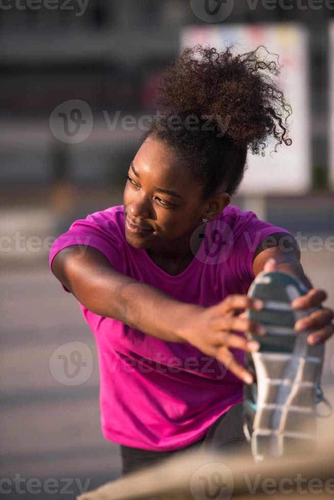 mulher afro-americana fazendo aquecimento e alongamento foto