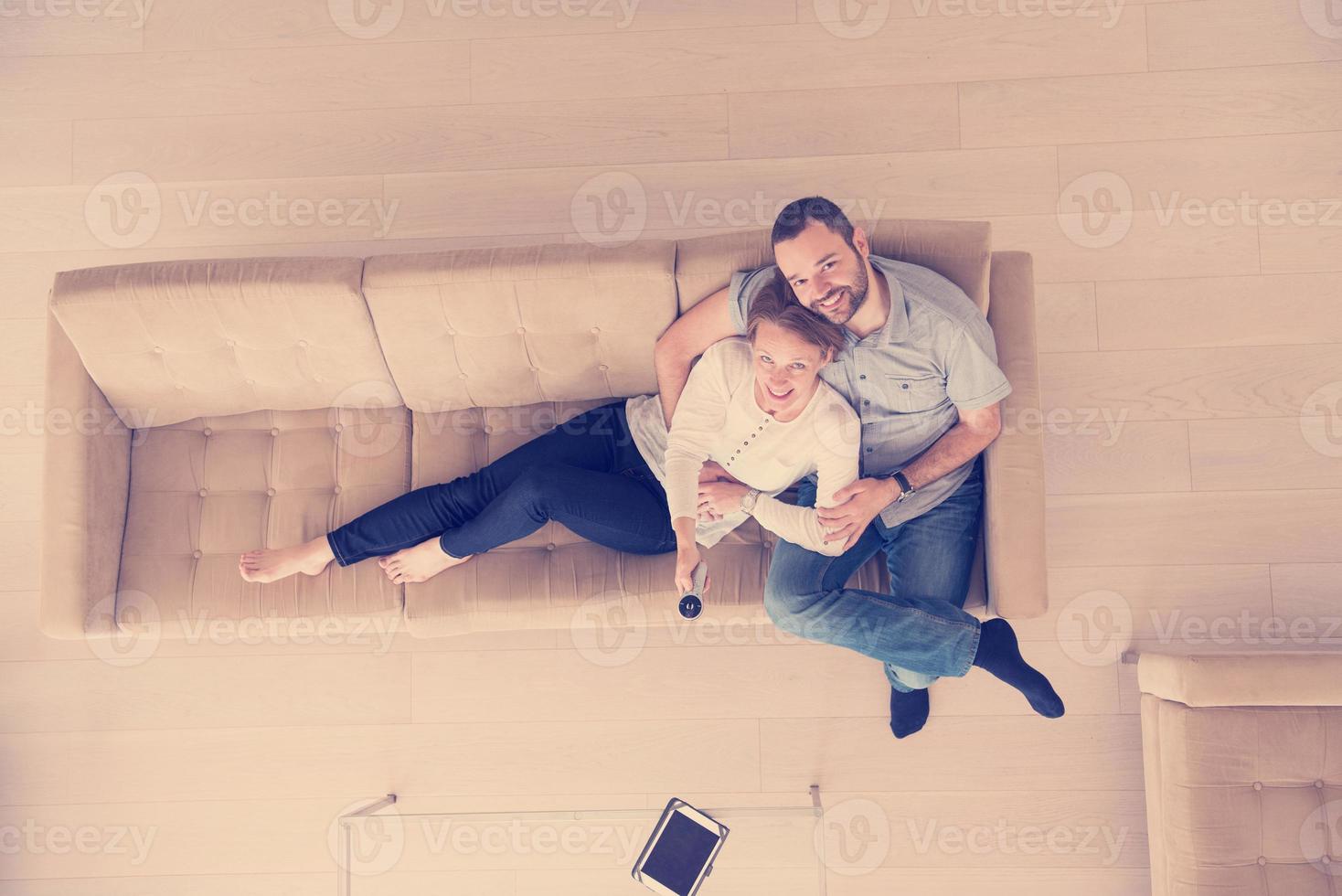 casal romântico no sofá assistindo televisão vista superior foto